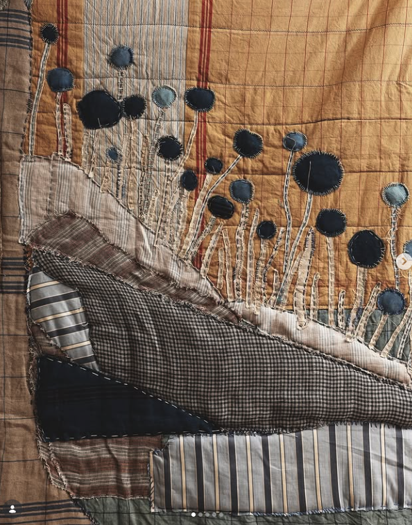 Handmade patchwork textile with stitched blue flower forms