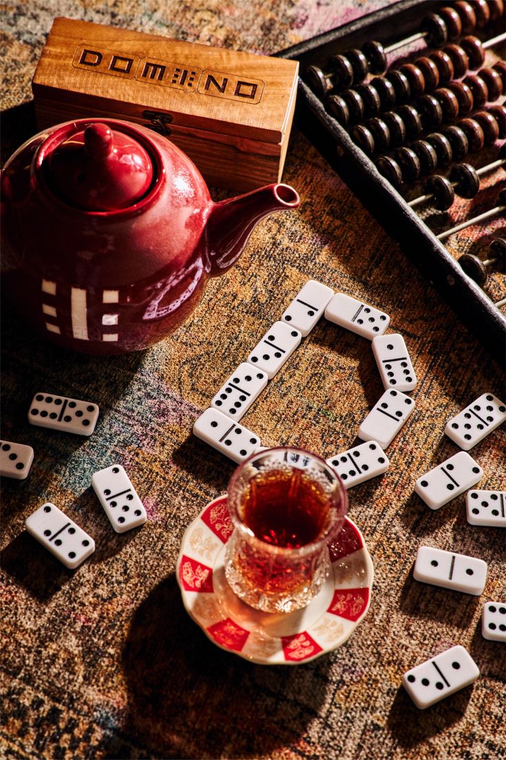 Dominoes, tea, an abacus and a wooden game box arranged on patterned cloth