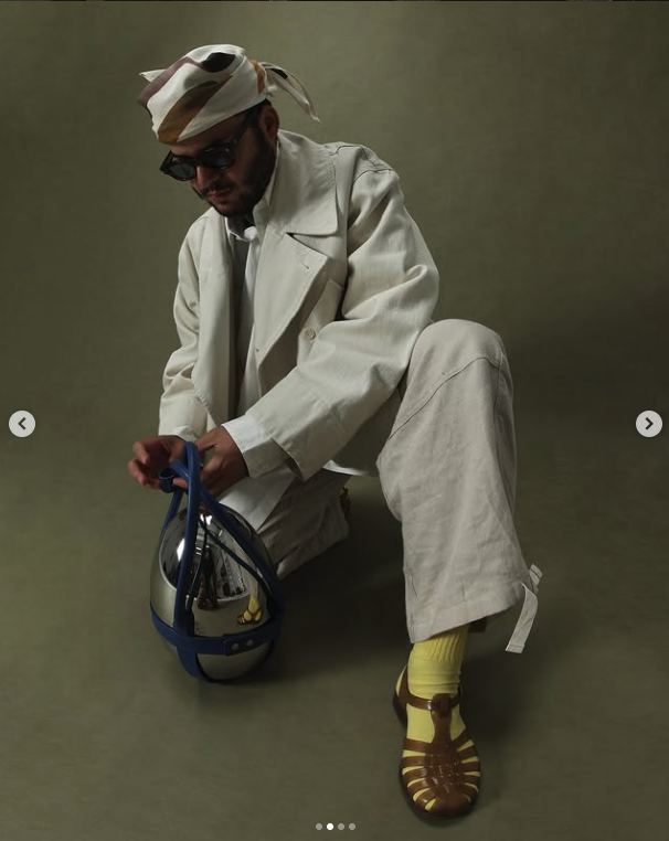 Layered cream tailoring styled with a headscarf, bright socks and sandals